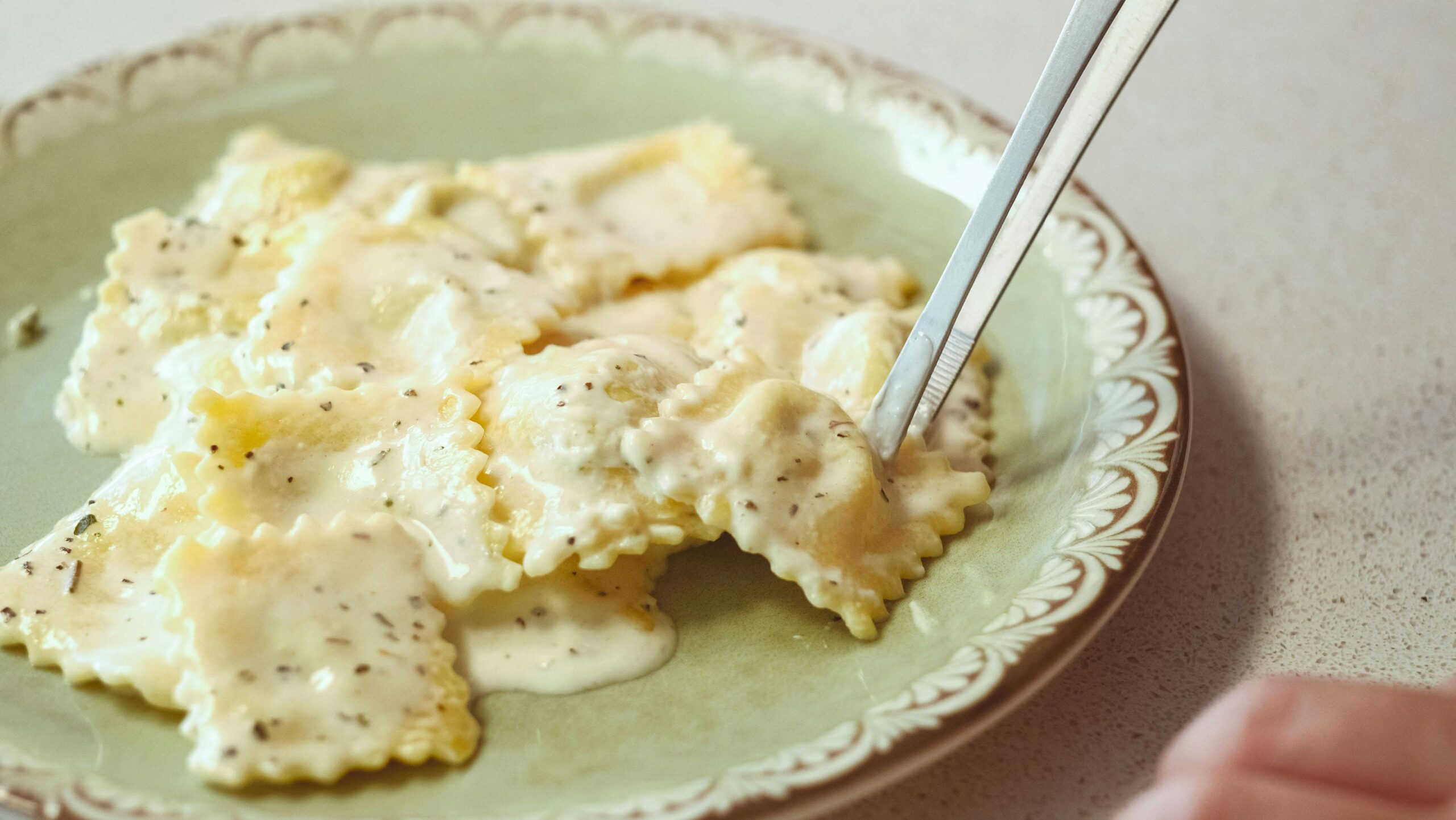 Close-up of ravioli with creamy sauce on a plate in Ankara, Türkiye.
