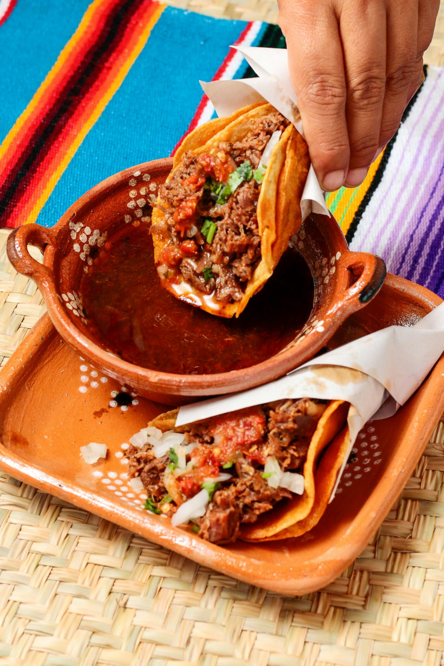 Delicious tacos served in a traditional Mexican platter with vibrant decor, ready to enjoy.