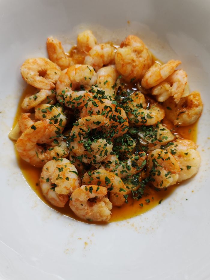 Tasty dish of garlic-infused shrimp with herbs in a savory sauce.