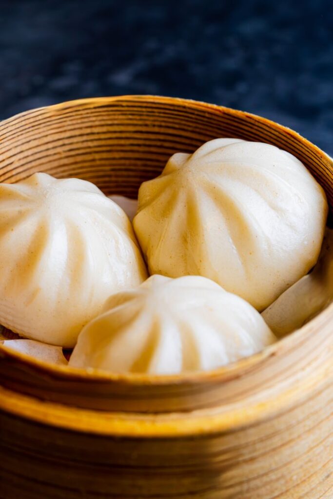 Delicious steamed dumplings in a traditional bamboo basket, perfect for Asian cuisine themes.